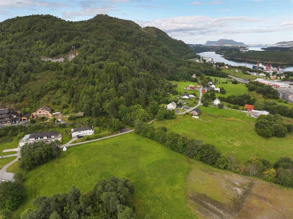 grøn natur med litt busetnad og anleggsområde i skogen - Klikk for stort bilete
