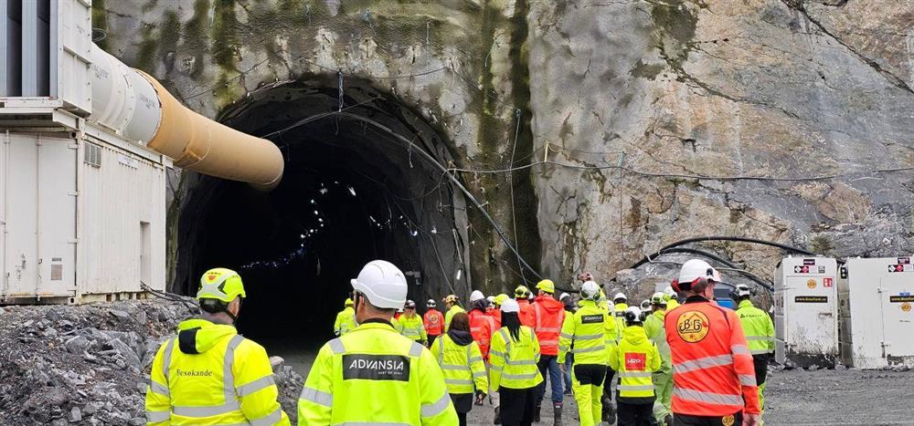 fleire personar i arbeidskle på veg inn i tunnel - Klikk for stort bilete