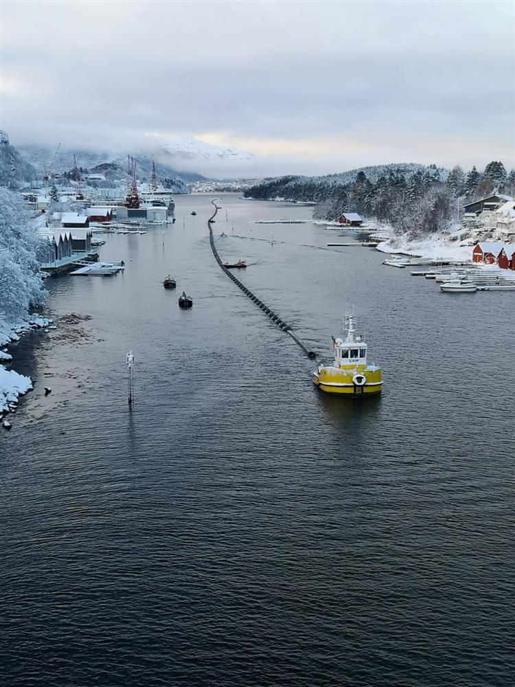 slep av sjøleidning gjennom sund med båtar som hjelper til - Klikk for stort bilete