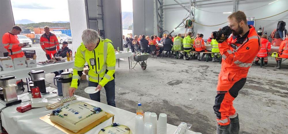 person som skjær stykke av kake og blir fotografert - Klikk for stort bilete