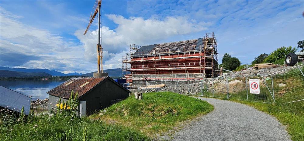 stort, raudt, uferdig hus og heisekran - Klikk for stort bilete