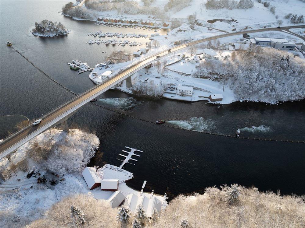 Slep av sjøleidning gjennom sund med småbåtar som hjelper til - Klikk for stort bilete
