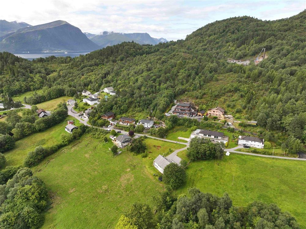 grøn natur med litt busetnad og anleggsområde i skogen - Klikk for stort bilete