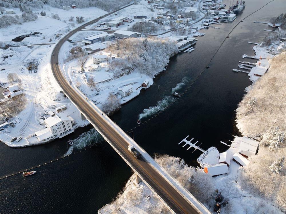 Slep av sjøleidning gjennom sund med småbåtar som hjelper til - Klikk for stort bilete